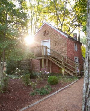 a path with trees on the side of a brick building