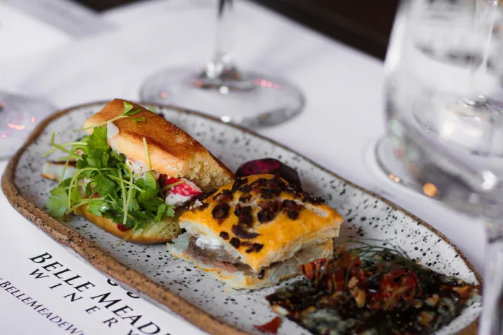 Close-up of a gourmet appetizer platter on a table with wine glasses.