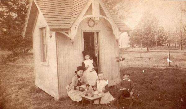 a vintage photo of a person sitting in front of a house
