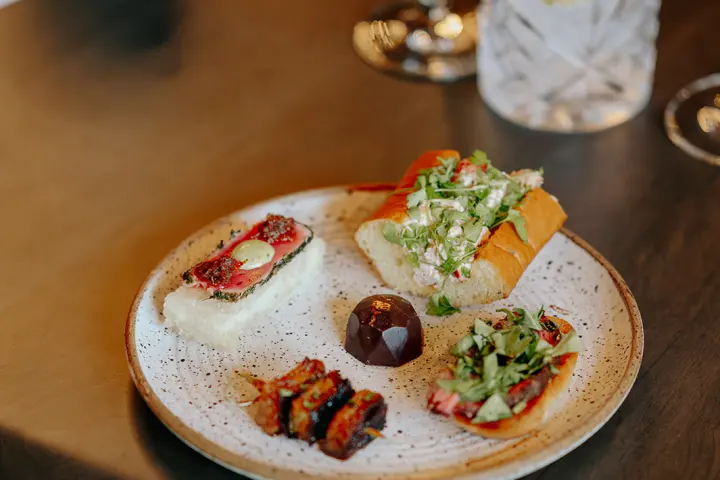 Assorted appetizers and a drink on a restaurant table.