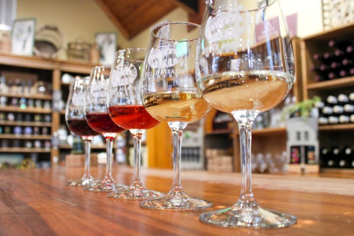 a glass of wine sitting on top of a wooden table