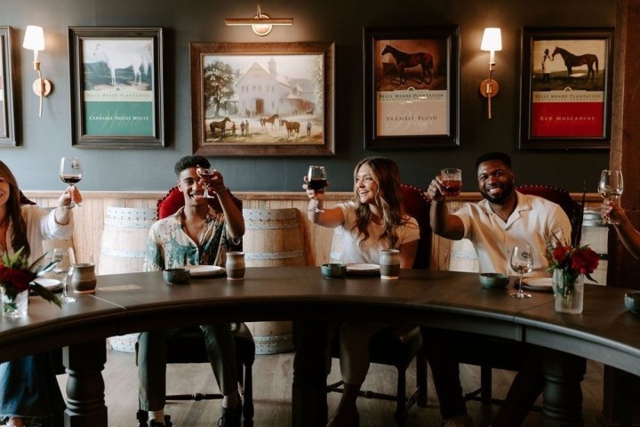 a group of people sitting at a table in front of a mirror