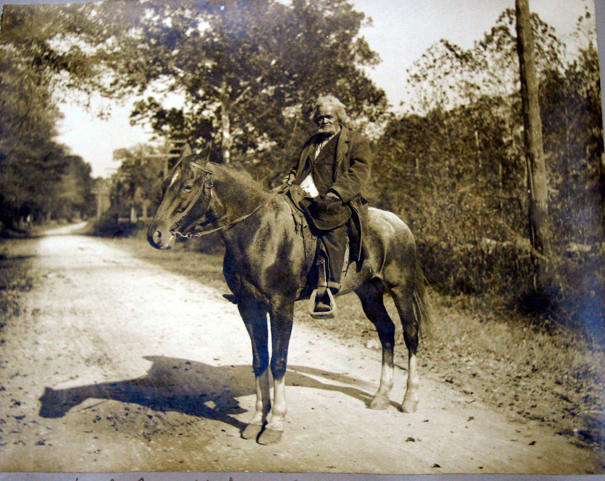 a man riding a horse on a dirt road